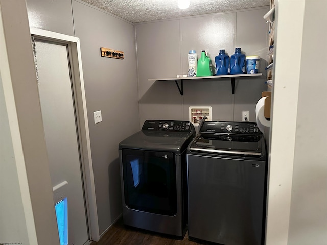 laundry area featuring washer and dryer, a textured ceiling, and dark hardwood / wood-style floors