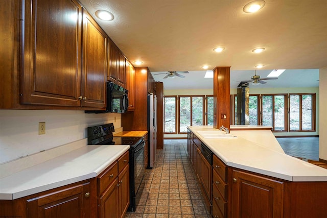 kitchen featuring black appliances, ceiling fan, sink, and a skylight