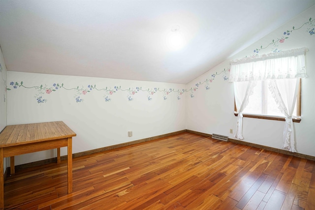 empty room featuring hardwood / wood-style floors and lofted ceiling