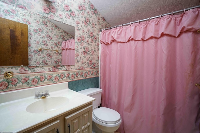 bathroom with vanity, toilet, and a textured ceiling