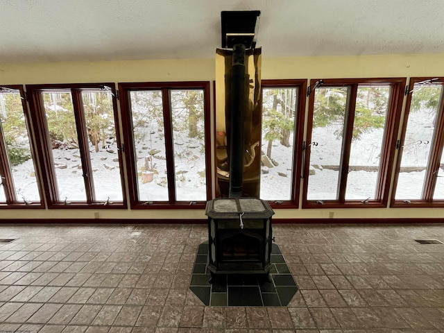 interior space with a textured ceiling and a wood stove