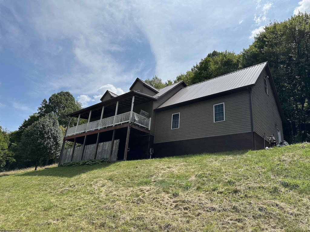 rear view of house featuring a yard and a deck