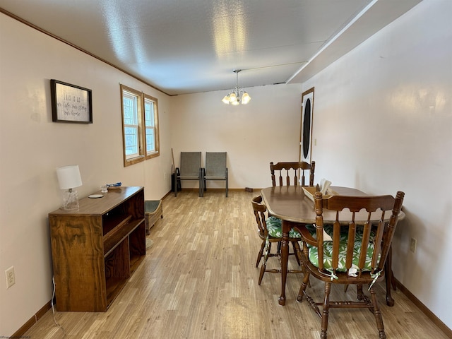 dining space with light hardwood / wood-style flooring and a chandelier