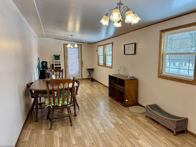 dining space featuring plenty of natural light, light hardwood / wood-style floors, and an inviting chandelier