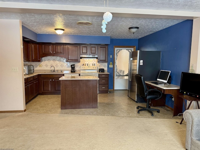 kitchen featuring decorative light fixtures, a kitchen island, dark brown cabinetry, and sink