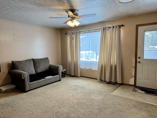 carpeted living room with ceiling fan and a textured ceiling