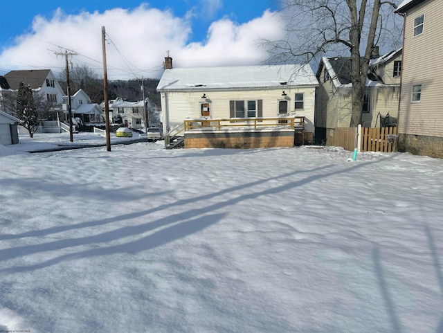 view of snow covered back of property