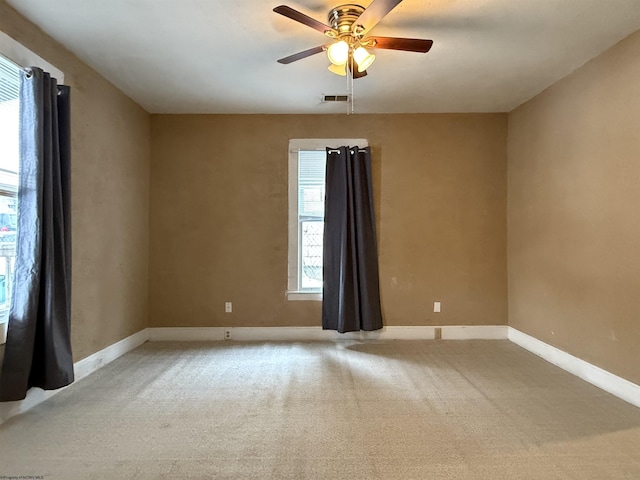 spare room featuring light carpet and ceiling fan