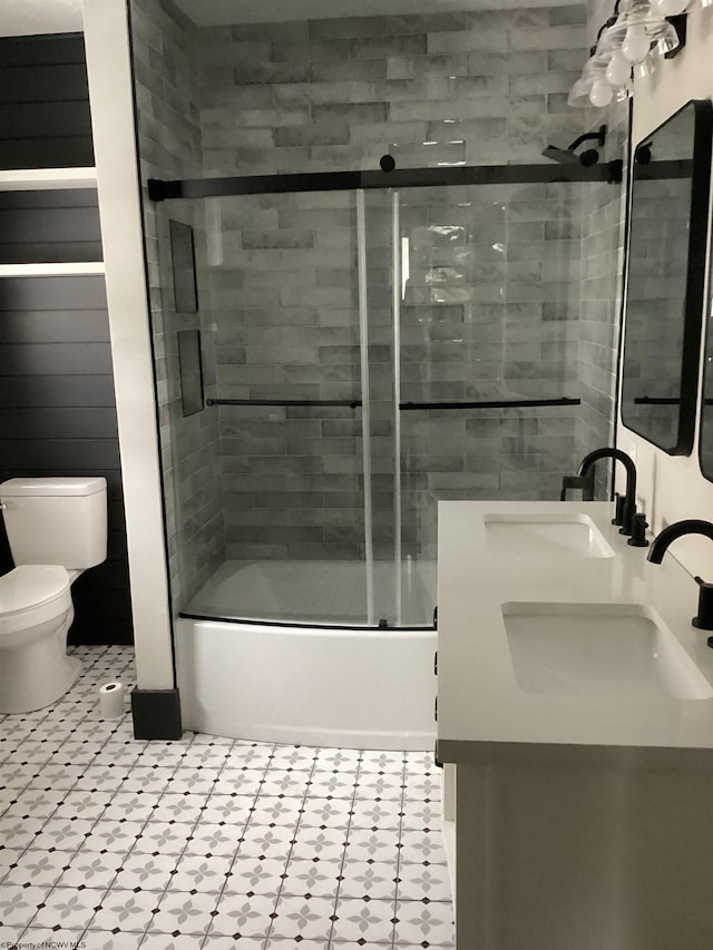 full bathroom featuring combined bath / shower with glass door, vanity, and toilet