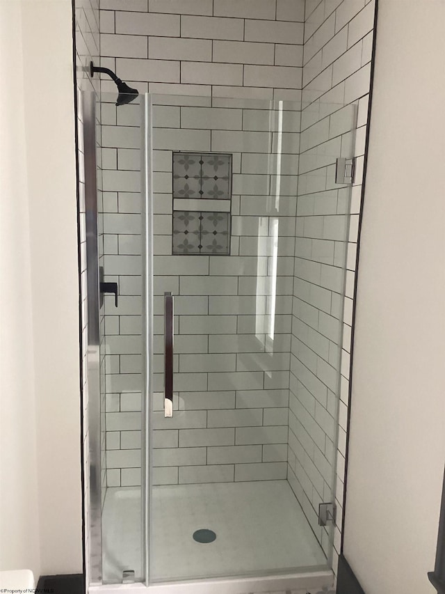 bathroom featuring a shower with shower door