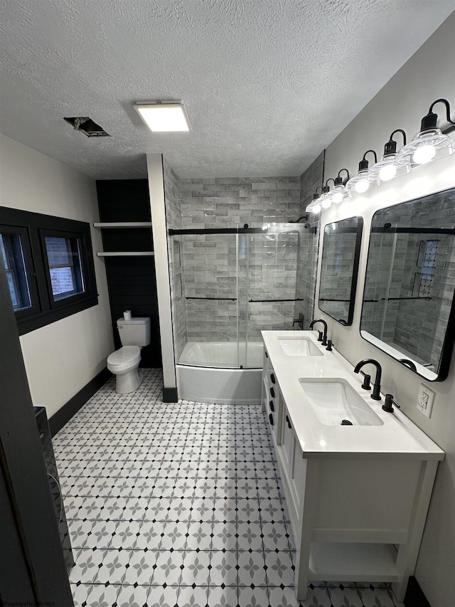 full bathroom with shower / bath combination with glass door, vanity, a textured ceiling, and toilet