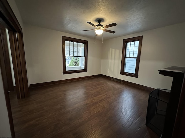 unfurnished room featuring a textured ceiling, dark hardwood / wood-style flooring, and ceiling fan