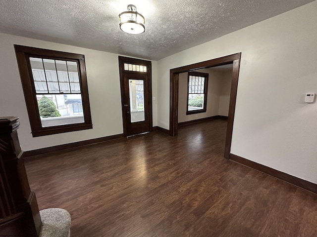 foyer with a textured ceiling and dark hardwood / wood-style flooring