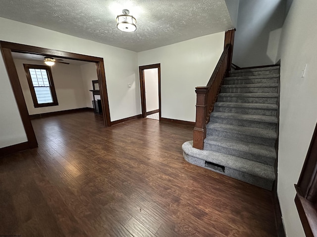 interior space featuring ceiling fan, wood-type flooring, and a textured ceiling