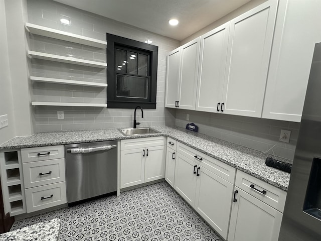 kitchen featuring dishwasher, white cabinetry, light stone countertops, and sink