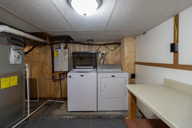 clothes washing area featuring heating unit, water heater, and washer and clothes dryer