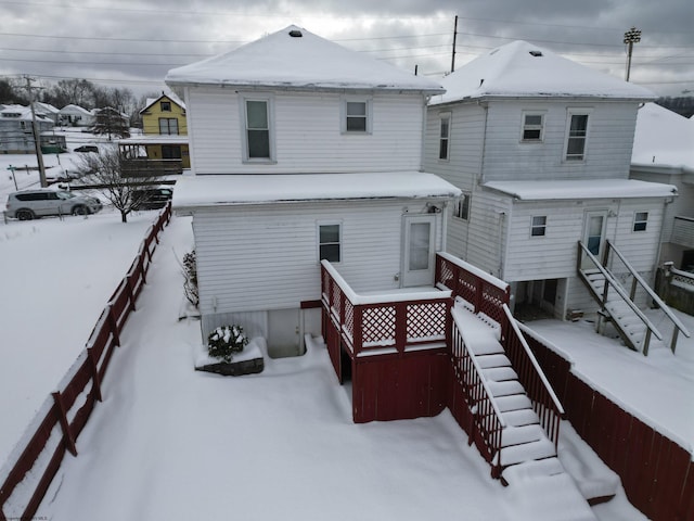 view of snow covered back of property