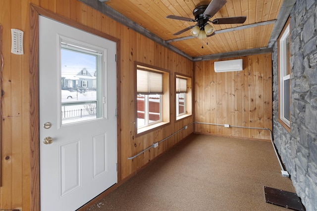 interior space with ceiling fan, a wall unit AC, wood walls, carpet, and wood ceiling