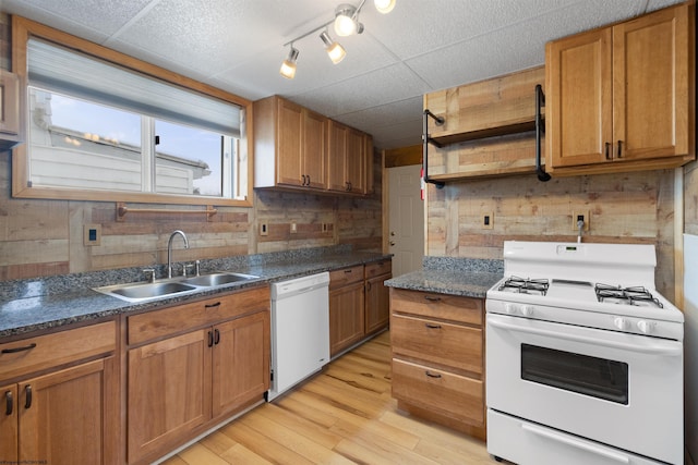 kitchen with light wood-type flooring, white appliances, and sink