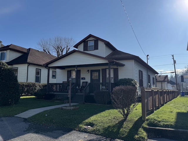 bungalow featuring covered porch and a front yard