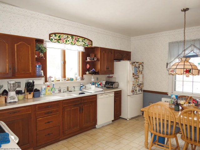 kitchen with white appliances, pendant lighting, and sink