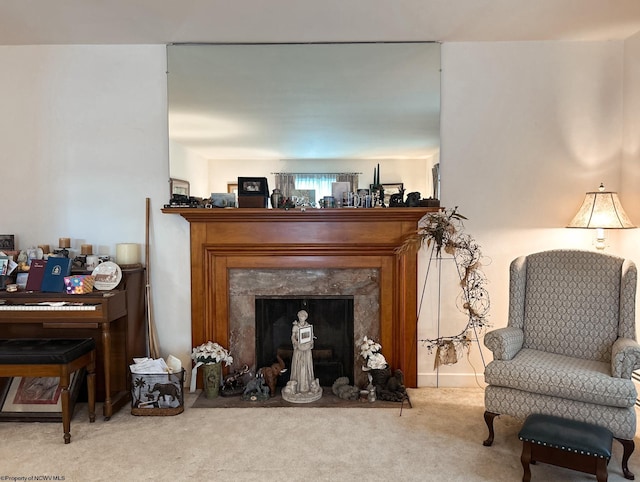 sitting room featuring a fireplace and carpet