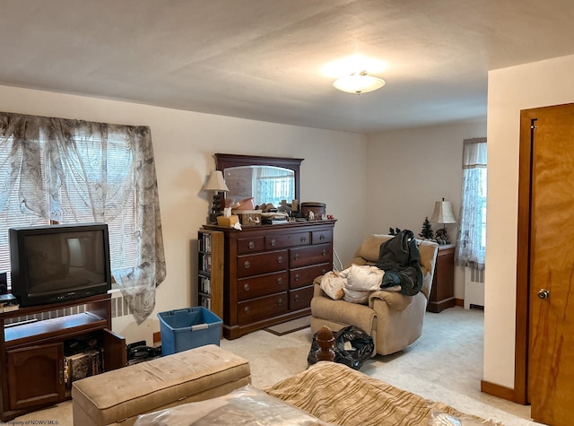 sitting room with light colored carpet and radiator heating unit