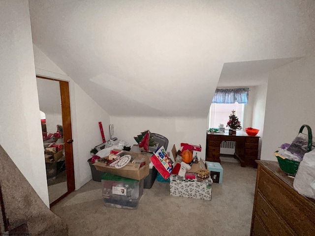 bonus room featuring lofted ceiling, radiator, and light carpet