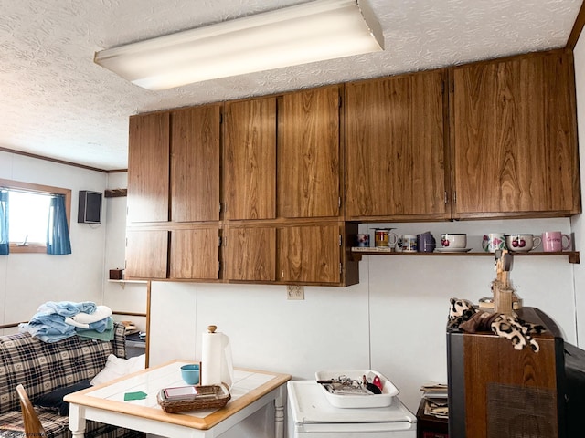 kitchen with tile counters, a textured ceiling, and crown molding