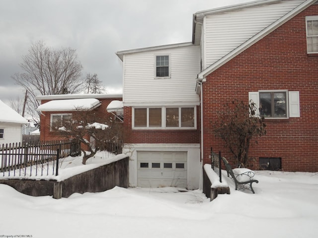 snow covered house with a garage