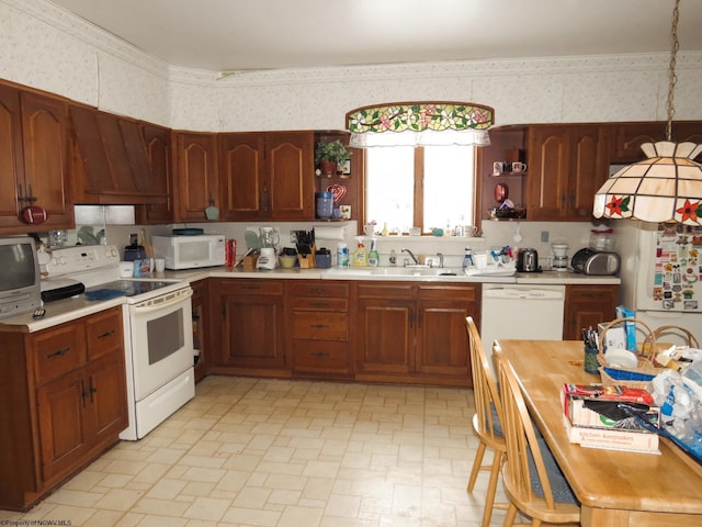 kitchen with sink, white appliances, and decorative light fixtures