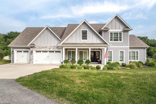 craftsman-style house with covered porch, a garage, and a front yard