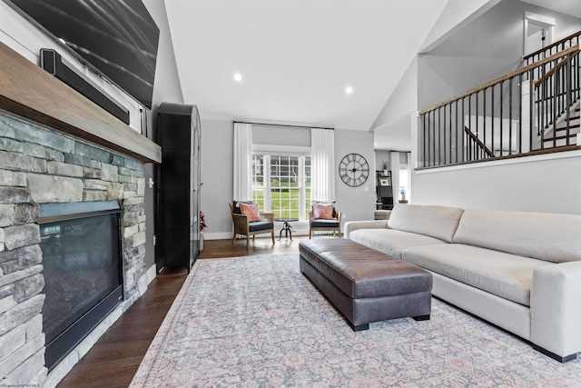 living room with lofted ceiling, a fireplace, and dark hardwood / wood-style flooring