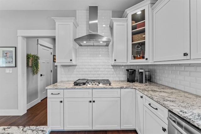 kitchen with stainless steel appliances, white cabinetry, light stone countertops, and wall chimney exhaust hood