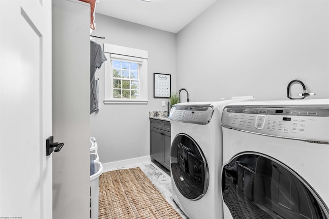 laundry room with separate washer and dryer and cabinets