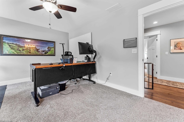 carpeted office space featuring ceiling fan