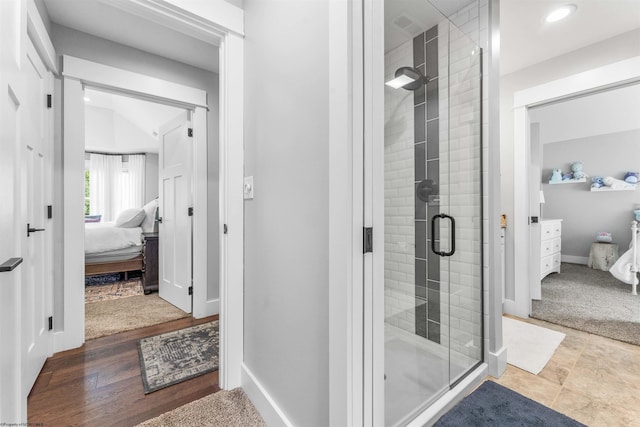 bathroom with a shower with door and hardwood / wood-style floors