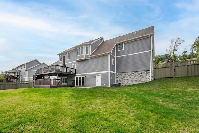 back of house featuring a lawn, a deck, and central air condition unit