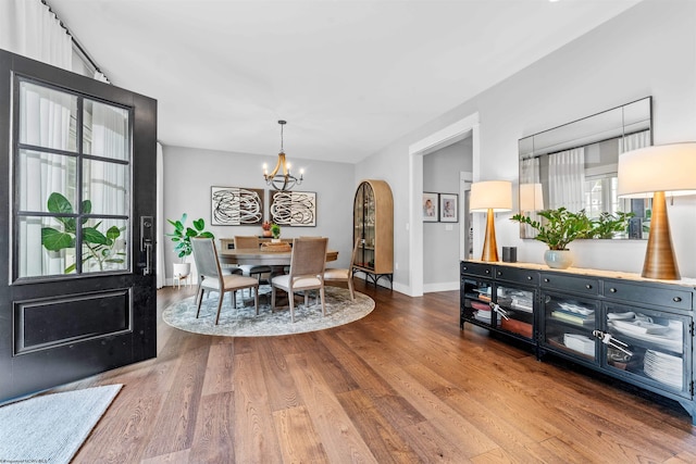 dining space with hardwood / wood-style flooring and an inviting chandelier