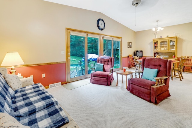 living room featuring ceiling fan with notable chandelier, vaulted ceiling, and carpet