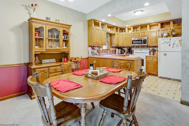 carpeted dining space featuring a raised ceiling