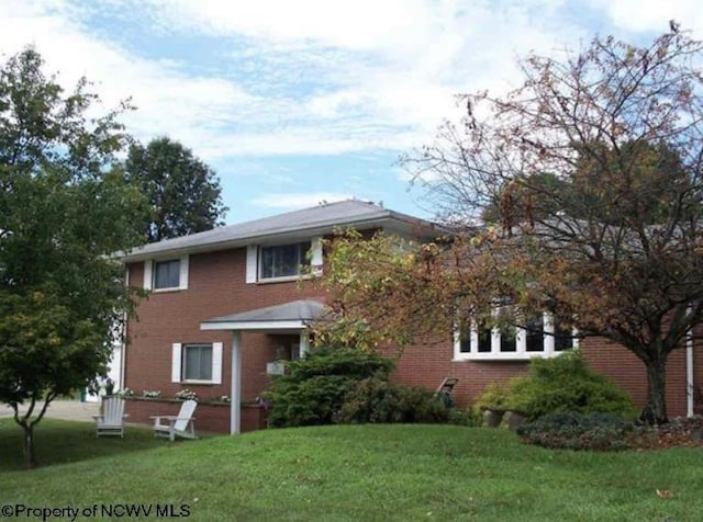 view of front of house featuring brick siding and a front lawn