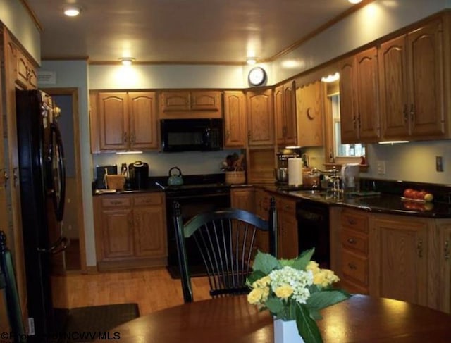 kitchen with brown cabinets, dark countertops, and black appliances