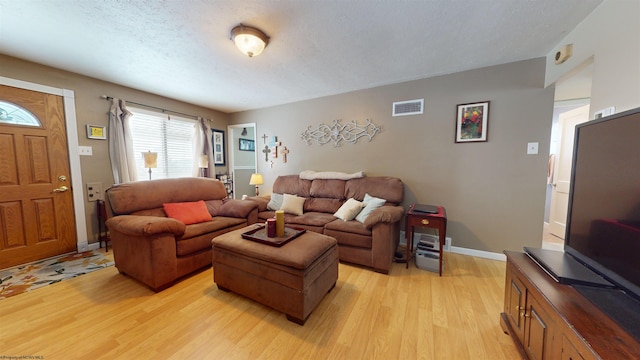 living room featuring a textured ceiling and light wood-type flooring