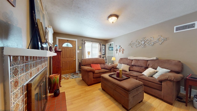 living room with light wood-type flooring and a textured ceiling