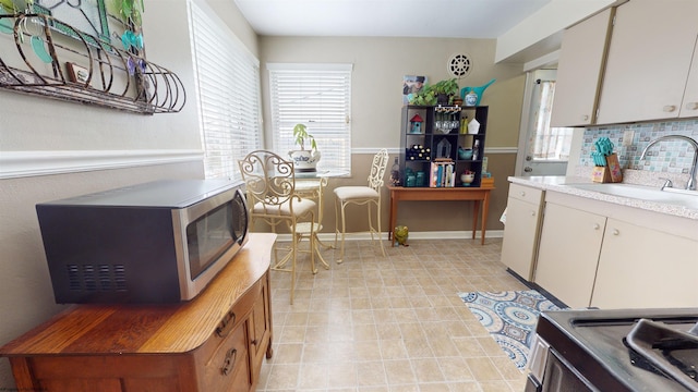 kitchen featuring white cabinets, tasteful backsplash, appliances with stainless steel finishes, and sink