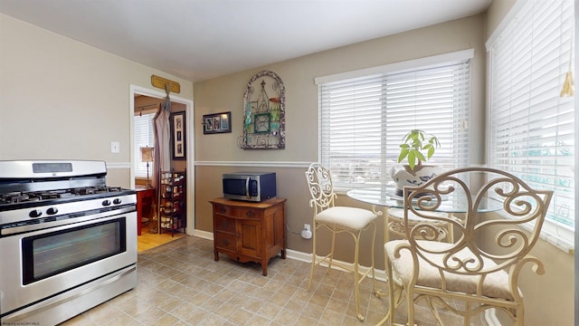 kitchen with light tile patterned flooring, plenty of natural light, and appliances with stainless steel finishes