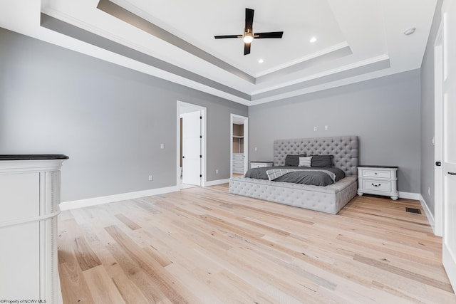 bedroom featuring a raised ceiling, ceiling fan, crown molding, and light hardwood / wood-style flooring