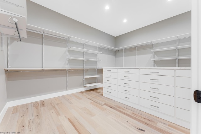 walk in closet with light hardwood / wood-style flooring