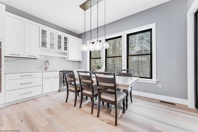 dining area featuring sink, a healthy amount of sunlight, and light hardwood / wood-style flooring